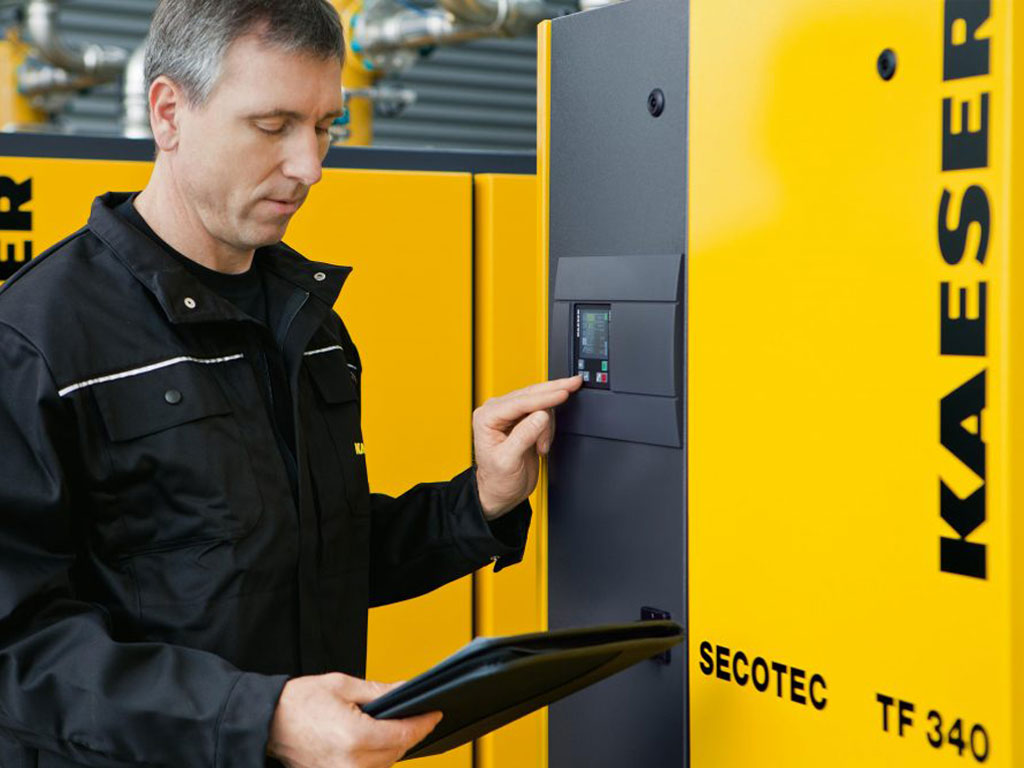 Kaeser-trained technician servicing a compressor control panel